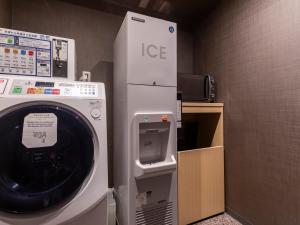 京都Tabist kiki HOTEL KYOTO Sanjo Takakura的客房内的洗衣机和烘干机