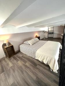 卡西斯Les Platanes的一间卧室设有一张大床,铺有木地板。