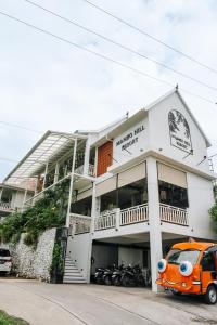 珀尼达岛Mambo Hill Resort的停在大楼前的一辆橙色卡车
