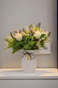 阿拉木图Апартаменты на Гагарина的白色的花瓶,上面摆放着鲜花