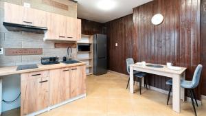 卡尔帕奇Eleven的厨房配有木制橱柜和桌椅
