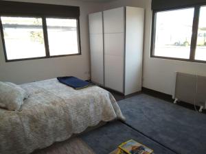 蒙蒂茹Privacidade na sua estadia no Centro do Montijo.的一间卧室设有一张床和两个窗户。
