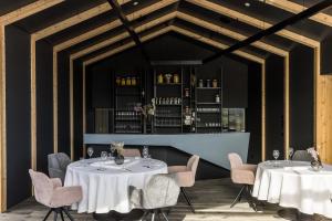 马莱斯韦诺斯塔白十字酒店的一间带2张桌子和椅子的餐厅和一间酒吧