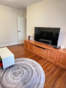 蒙达卡Apartamento Ideal的木质娱乐中心设有带平面电视的客厅。
