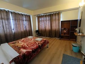 大吉岭New Maya Residency的一间卧室配有一张带红色毯子的床