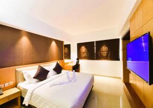 特里凡得琅Akhil Classic的一间卧室配有一张床和一台平面电视