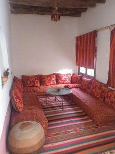 斯库拉达累斯萨拉姆酒店的客厅配有红色的沙发和桌子
