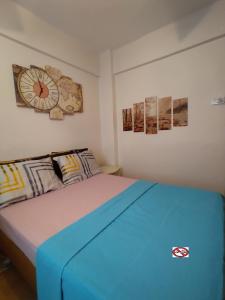 伊斯坦布尔Feeling at home in İstanbul Center 5 Minutes walk to The Ataköy Metro Station & Metrobus的墙上挂有时钟的房间里一张床位