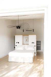 圣马迪拉莫Mas de la Fouque - Hôtel & Spa的白色卧室配有白色的床和吊灯