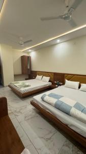 乌贾因Hotel Prakasham的大客房内设有两张床,
