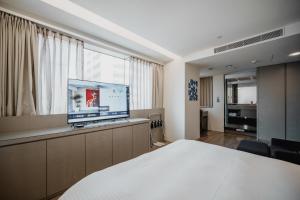 高雄旅居文旅 高雄亚湾馆的配有一张床和一台平面电视的酒店客房