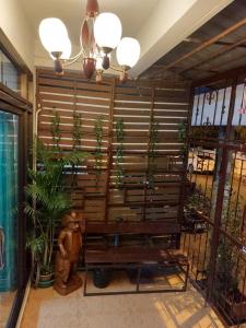 Ban Tha SaeClassic Home Stay Hatyai的木凳坐在植物间
