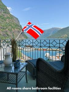 弗洛姆Svingen Guesthouse - Panoramic Fjord Views in Flåm的阳台的一张英国国旗,配有桌椅