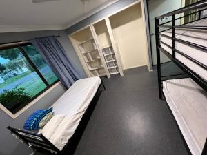 班达伯格Tomato Backpackers的一间卧室设有两张双层床和一扇窗户。