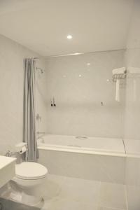 合艾新季节酒店的白色的浴室设有浴缸、卫生间和水槽。