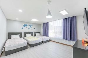 丽水市Jin Arirang Hostel的一间卧室配有两张床和电视。