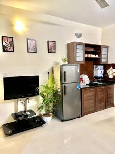 瓦加托BohoLush by Evanka的厨房配有不锈钢冰箱和电视。