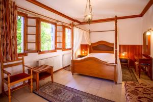 美特索文阿多尼斯酒店的一间卧室配有一张天蓬床和一张书桌