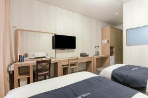 仁川市Incheon Aiport Airrelax hotel的酒店客房配有书桌和电视。