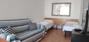 帕图Casa Milagros的客房设有两张床、一张沙发和镜子