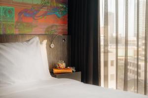 埃因霍温Crown Hotel Eindhoven Centre的靠窗的带白色枕头的床
