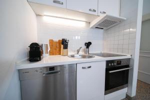 杜塞尔多夫Apartments - Kitchen & More的一个带水槽和洗碗机的厨房