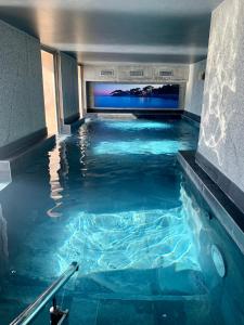 邦多勒Splendid Hôtel & Spa的一座蓝色海水室内游泳池,位于一座建筑中