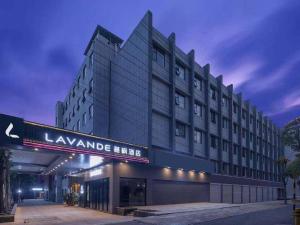 武汉Lavande Hotels Wuhan Guanggu Yangjiawan Metro Station的一座大建筑,上面有读豪华旅馆的标志