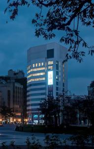 台中市路得行旅国际青年旅馆台中站前馆的一座高大的建筑,城市里灯火通明