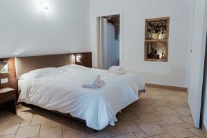 雷扎托Hotel Alla Sosta的一间卧室配有一张带白色床单的大床