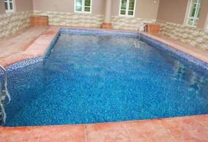 OgbodoAyoluyem Aparthotel and Suites的蓝色海水大型游泳池