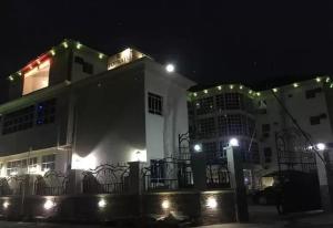 奥韦里Top Rate Hotel的白色的建筑,晚上有灯