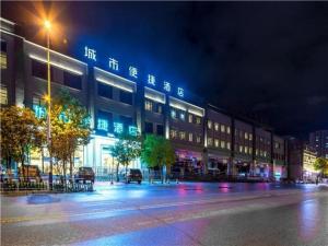 昆明City Comfort Inn Kunming Qianxing Road Dashanghui Children's Hospital的夜幕降临的城市街道上