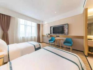 昆明City Comfort Inn Kunming Qianxing Road Dashanghui Children's Hospital的一间酒店客房,设有两张床和电视