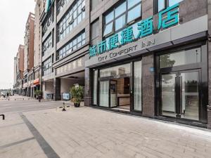 成都City Comfort Inn Chengdu Southwest University of Finance and Economics Wansheng Metro Station的城市街道上的建筑物