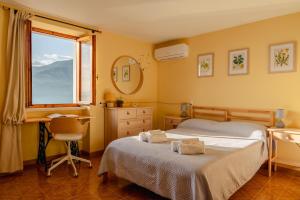 布雷佐内加尔达Garda Doma的一间卧室设有两张床、一张桌子和一个窗口。