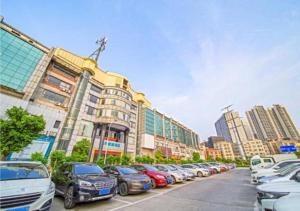 四会City Comfort Inn Zhaoqing Sihui International Jade City Sihui Plaza的停在大楼前的一排汽车