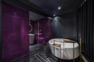 北京Blossom House Beijing Houhai的紫色浴室设有浴缸和两个水槽