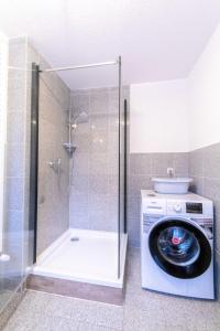 普鲁滕Ferienhaus Ostsee - a70522的带淋浴的浴室内的洗衣机