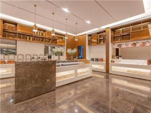 大理E-Cheng Hotel Dali High-Speed Railway Station Erhai Lake的一间铺有大理石地板并配有木制橱柜的大厨房