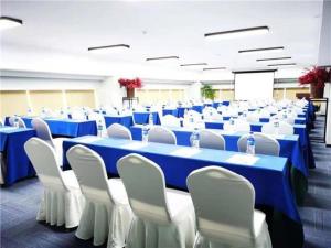 大理E-Cheng Hotel Dali High-Speed Railway Station Erhai Lake的大房间设有蓝色的桌子和白色的椅子
