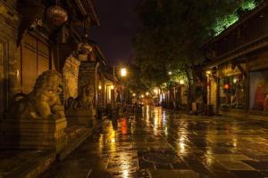 成都Borrman Hotel Chengdu Chunxi Road Tianfu Square Metro Station的夜晚有雨的城市街道