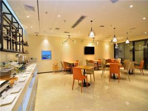 昆明City Comfort Inn Kunming Flower City Midea Shuncheng Mansion的一间在房间内配有桌椅的餐厅