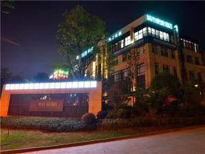 昆明City Comfort Inn Kunming Flower City Midea Shuncheng Mansion的一座晚上有灯的建筑