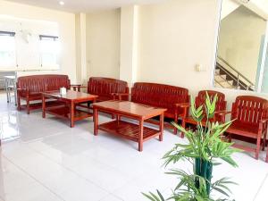 班杜SC Palace Chiangrai Hotel的一间设有长椅和桌子以及镜子的等候室