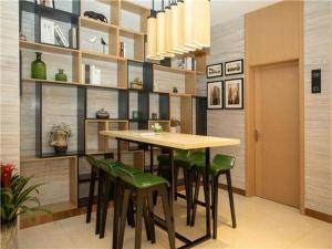 江都City Comfort Inn Yangzhou Jiangdu North Limin Road的一间带桌子和绿色椅子的用餐室