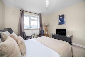 伦敦The Wimbledon Park Luxury Room的卧室配有白色的床和电视。