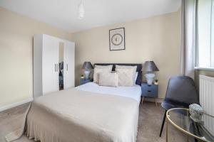 伦敦The Wimbledon Park Luxury Room的卧室配有白色的床和蓝色椅子