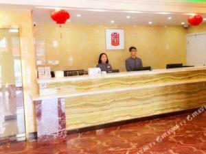 上海Ease Hotel Shanghai Chuanhuan Nan Road Chuansha Metro Station的两名坐在酒店大堂柜台的宾客