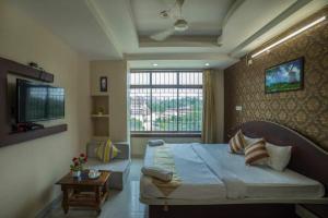 古瓦哈提Asian Suites Guwahati的一间卧室设有一张大床和一个窗户。